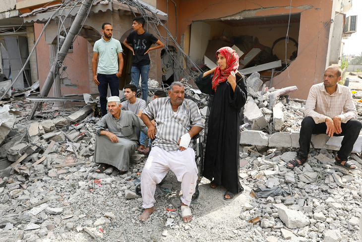 Người Palestine ở phía nam dải Gaza đang quan sát lực lượng cứu hộ tìm kiếm người mắc kẹt trong đống đổ nát sau cuộc không kích đáp trả của Israel, ngày 8-10 - Ảnh: REUTERS