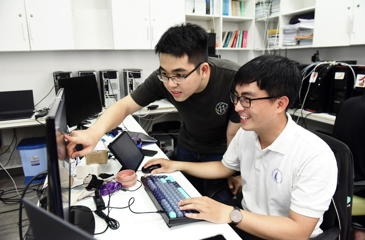 Nguyễn Đại Nghĩa (ngồi) cùng đồng nghiệp trao đổi tại phòng thí nghiệm công nghệ phần mềm (SELab) Trường ĐH Khoa học tự nhiên, ĐH Quốc gia TP.HCM - Ảnh: DUYÊN PHAN