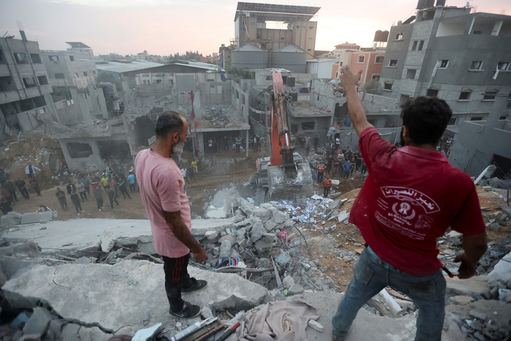 Người dân Palestine tìm kiếm người gặp nạn tại một tòa nhà dân cư bị Israel tấn công ở trung tâm Dải Gaza, ngày 31-10 - Ảnh: REUTERS