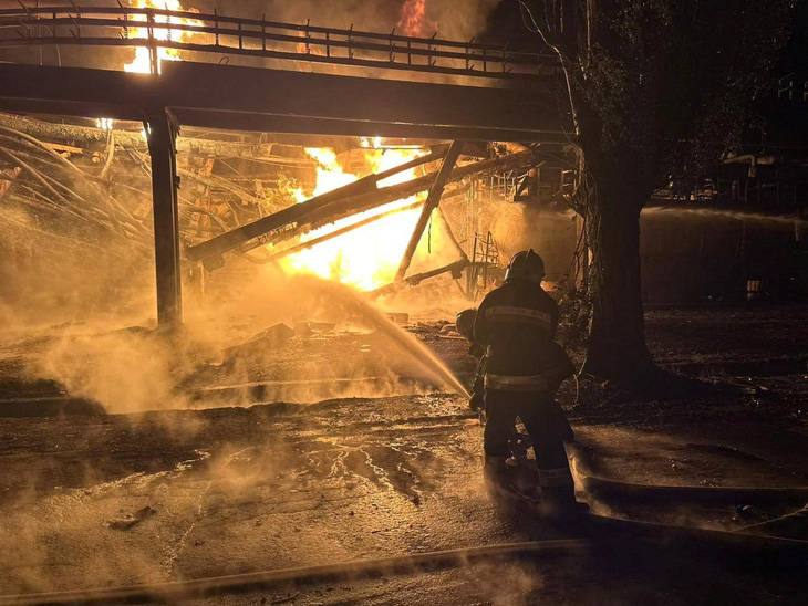 Lính cứu hỏa khống chế ngọn lửa tại nhà máy lọc dầu ở Kremenchuk, Ukraine - Ảnh: REUTERS