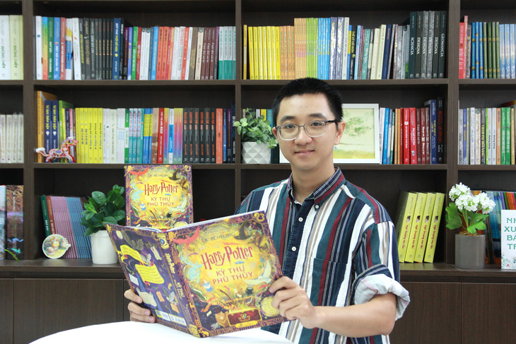 Họa sĩ Phạm Quang Phúc cùng cuốn sách anh tham gia vẽ minh họa - Ảnh: NXB Trẻ cung cấp