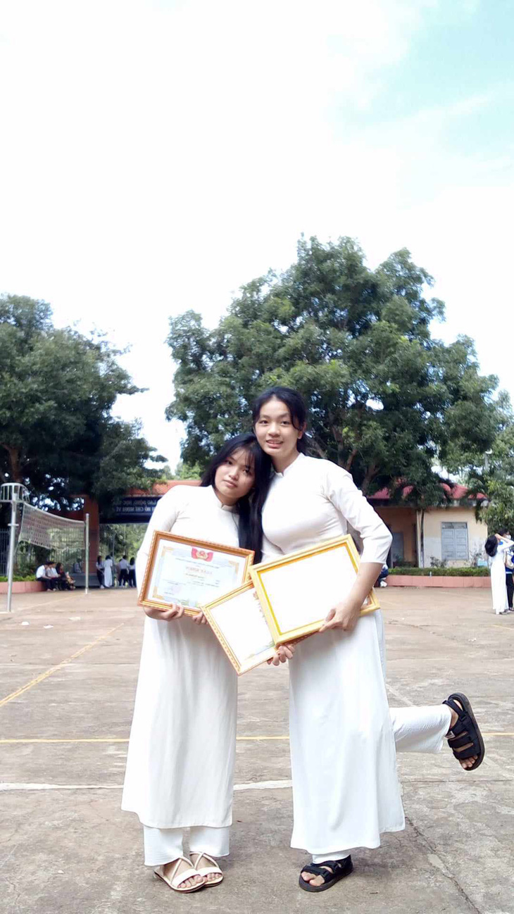 Phương Linh (phải) và Bình An ngày nhận giấy khen ở Trường THPT Phạm Văn Đồng - Ảnh: L.P.