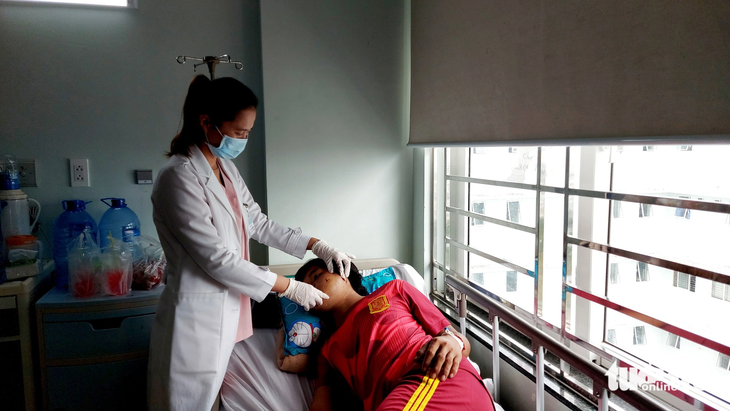 Bác sĩ Bệnh viện Đa khoa tỉnh Kiên Giang thăm khám sức khỏe cho anh Đ. khi bị đạn chì bắn xuyên từ má ra sau lỗ tai trái - Ảnh: CHÍ CÔNG