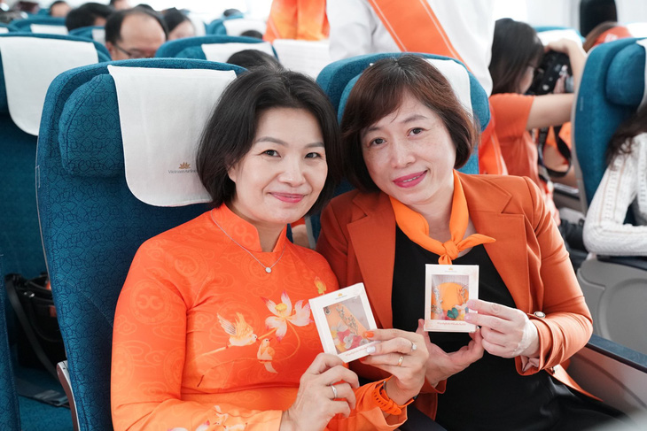 Hành khách nhận quà mang thông điệp bình đẳng giới trên chuyến bay của Vietnam Airlines - Ảnh: M. NGỌC
