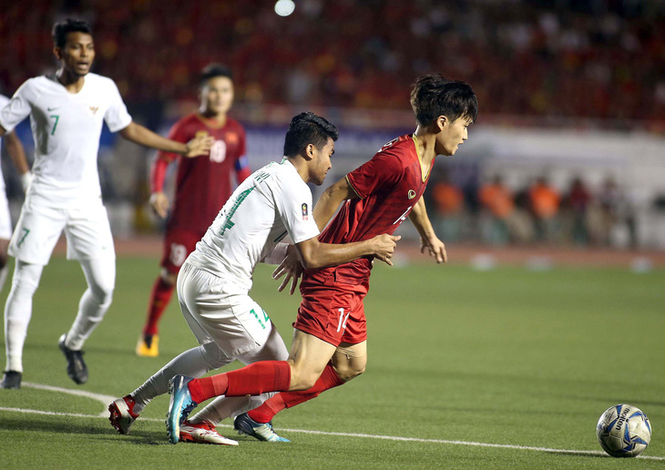 Hoàng Đức (phải) trên mặt sân cỏ nhân tạo Rizal Memorial ở SEA Games 2019 - Ảnh: N.K.