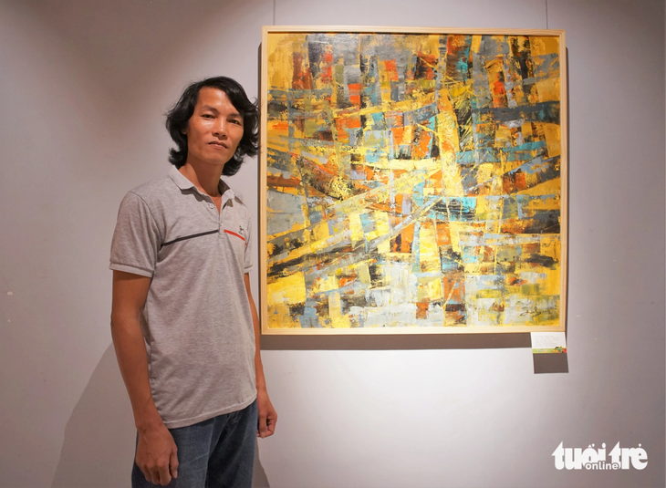 Họa sĩ Hà Bình Nhưỡng bên tác phẩm tại triển lãm &quot;Song hành&quot; - Ảnh: H.VY