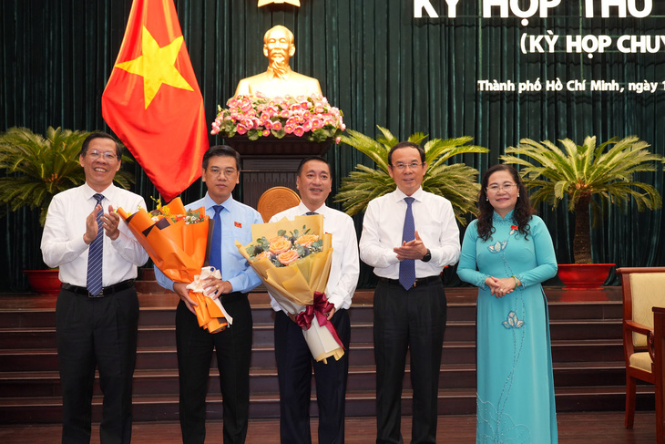 Lãnh đạo TP.HCM trao hoa chúc mừng ông Nguyễn Văn Dũng (áo xanh) được bầu làm phó chủ tịch UBND TP.HCM và ông Phạm Thành Kiên (chính giữa) làm phó chủ tịch HĐND TP.HCM - Ảnh: HỮU HẠNH