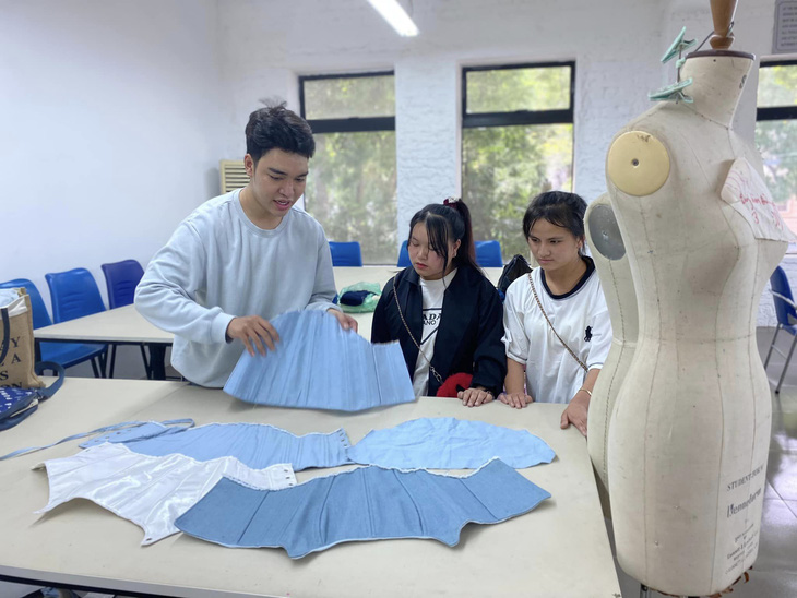 Các thiếu nữ Mông học kỹ thuật mới của ngành thời trang dưới sự hướng dẫn của các bạn sinh viên tại trường - Ảnh: BTC