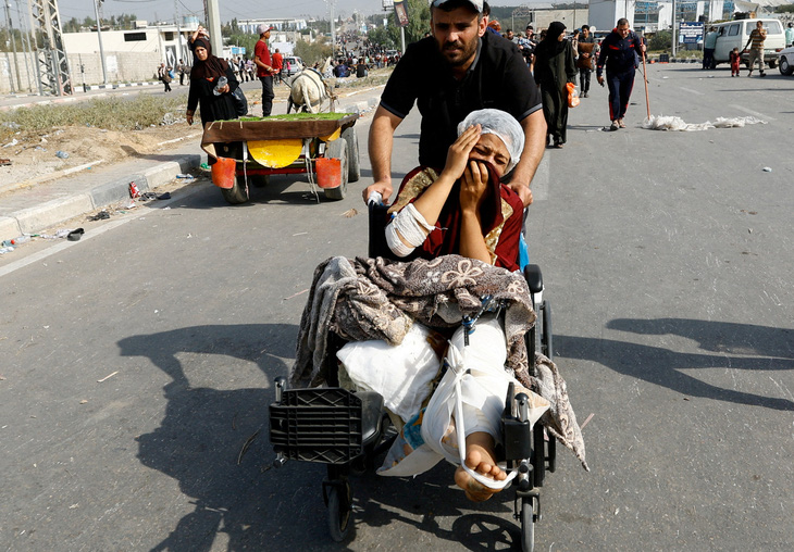 Một phụ nữ Palestine, bị thương trong một cuộc tấn công của Israel và từng ở Bệnh viện Al-Shifa, sơ tán về phía nam ngày 10-11 - Ảnh: REUTERS