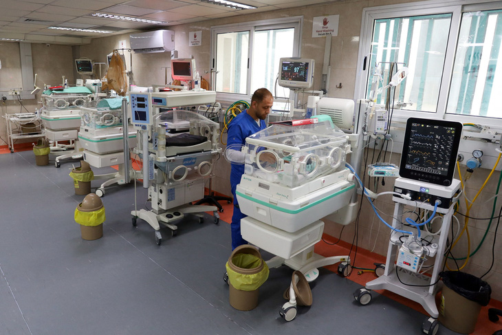 Nhân viên y tế chăm sóc trẻ sơ sinh trong lồng ấp tại bệnh viện al-Shifa - Ảnh: REUTERS