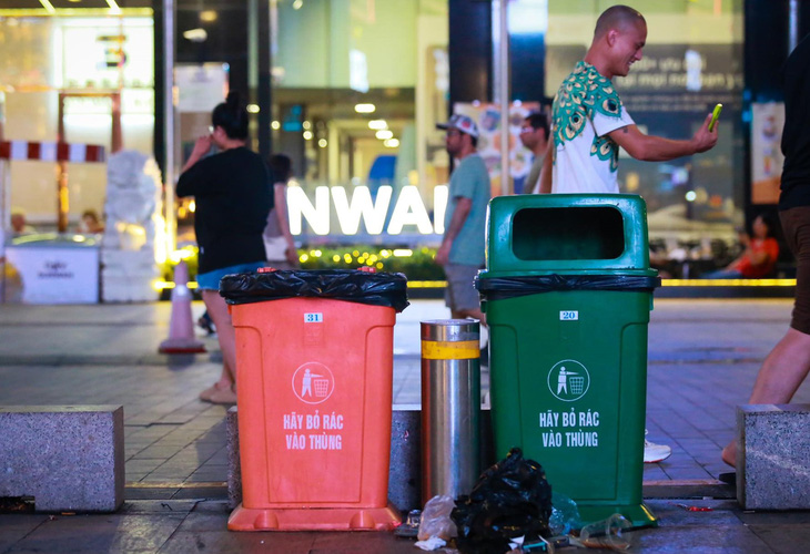Khẩu hiệu &quot;Hãy bỏ rác vào thùng&quot; nhưng rác vẫn quăng bừa bãi ở phố đi bộ Nguyễn Huệ - Ảnh: PHƯƠNG QUYÊN
