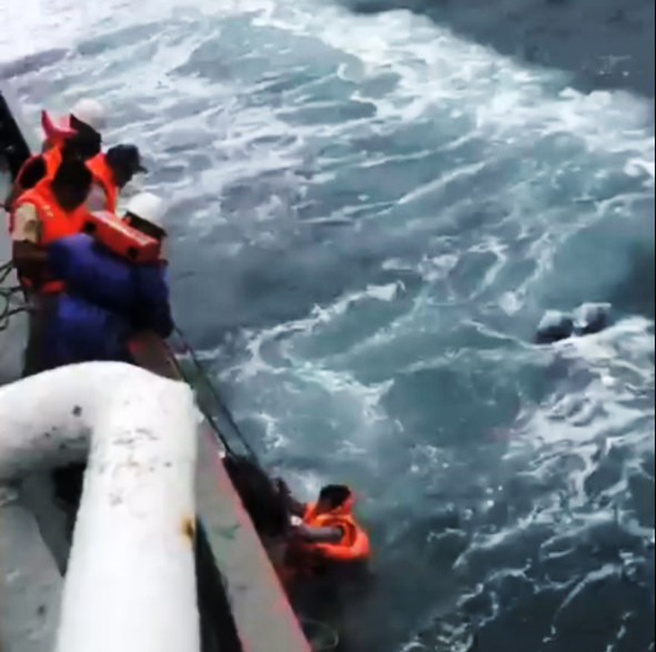 Thuyền viên tàu Hoàng Sa 126 cứu hộ hai người trên sà lan bị trôi dạt nhiều giờ trên biển Thừa Thiên Huế - Ảnh: Cắt từ clip của tàu Hoàng Sa 126