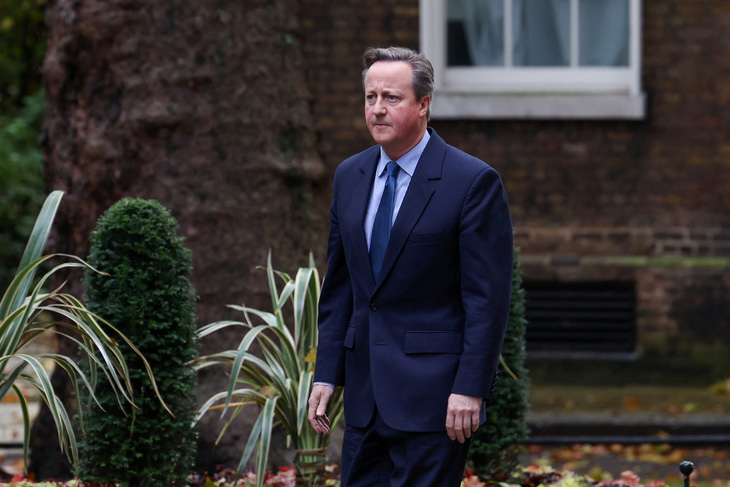 Cựu thủ tướng Anh David Cameron đi bộ đến Văn phòng Thủ tướng sáng 13-11 - Ảnh: REUTERS