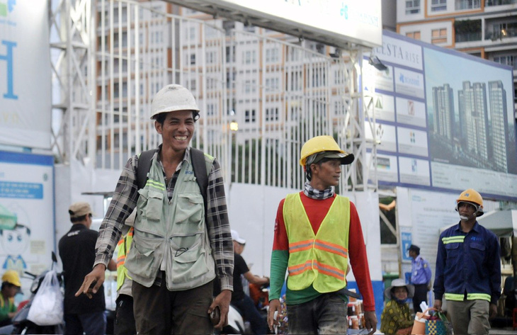 Công nhân tan ca tại công trường xây dựng dự án bất động sản trên đường Nguyễn Hữu Thọ, huyện Nhà Bè, TP.HCM - Ảnh: TỰ TRUNG