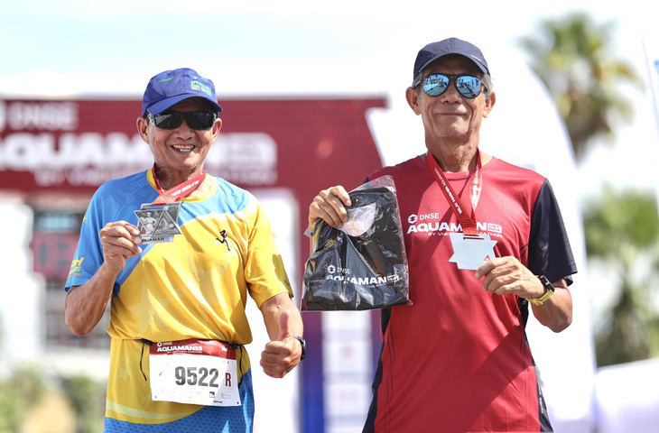 Hai lão niên Phạm Quốc Lương, Dương Thế Hùng nhận huy chương sau khi hoàn thành cuộc đua - Ảnh: NVCC