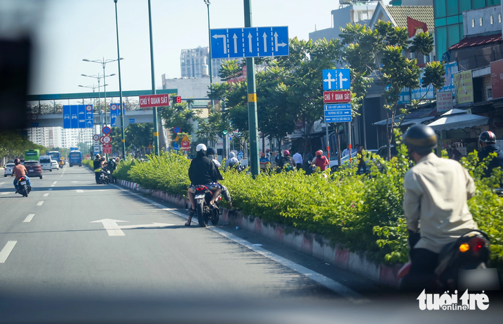 Thấy chốt của Đội cảnh sát giao thông Hàng Xanh, hàng loạt xe máy đang chạy vào đường cấm (làn ô tô đường Phạm Văn Đồng) quay đầu bỏ chạy - Ảnh: CHÂU TUẤN