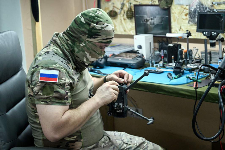 Một binh sĩ đang sửa chữa máy bay không người lái (drone) tại Nga - Ảnh: IZVESTIA