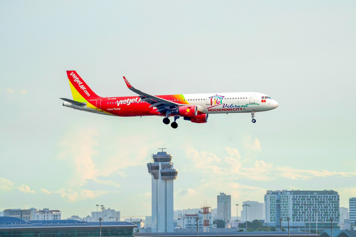 Tàu bay Vietjet sắc đỏ vàng rực rỡ và biểu tượng Du lịch Việt Nam trên thân máy bay.