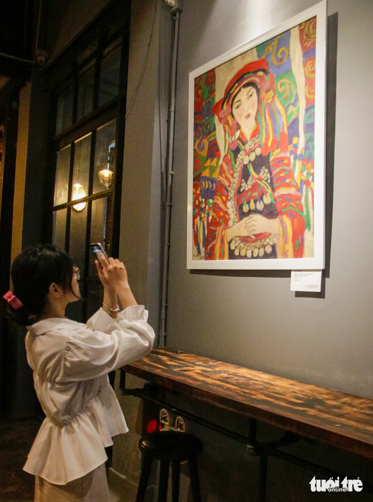 Bạn trẻ ghi lại những mảng màu sắc rực rỡ trong tác phẩm sơn dầu "Thiếu nữ H’Mông" của họa sĩ Bùi Văn Quang - Ảnh: HỒ LAM