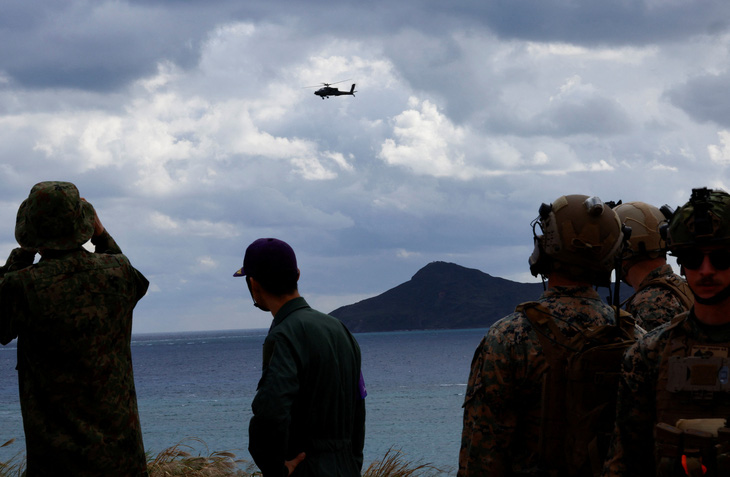 Trực thăng AH-64 Apache của Lực lượng phòng vệ mặt đất Nhật Bản bay phía trên các binh sĩ thuộc Lữ đoàn triển khai đổ bộ và Thủy quân lục chiến Mỹ trong cuộc tập trận quân sự tại đảo không có người ở Irisuna, tỉnh Okinawa, Nhật Bản, ngày 15-11 - Ảnh: REUTERS