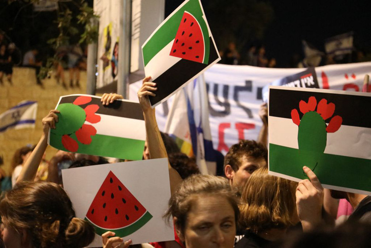 Người ủng hộ mang theo hình cờ Palestine được biến tấu từ quả dưa hấu và các màu sắc liên quan xuống đường phố Israel tuần hành hồi tháng 7, sau khi Bộ trưởng An ninh Israel Itamar Ben Gvir cấm vẫy cờ Palestine - Ảnh: GETTY IMAGES