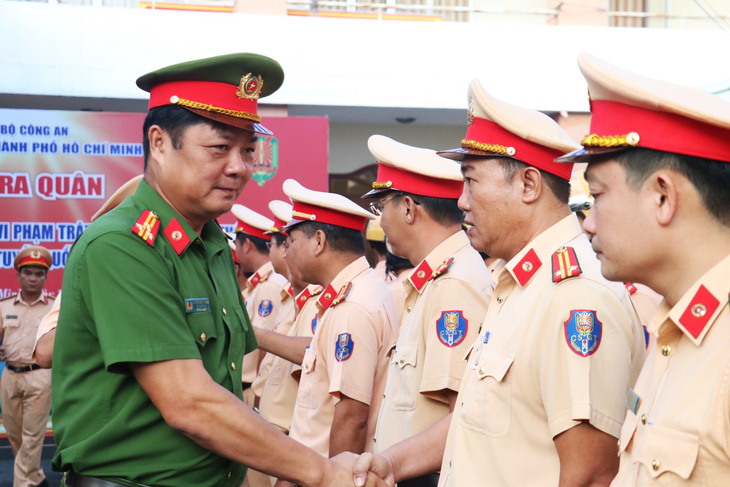 Thượng tá Nguyễn Đình Dương - phó giám đốc Công an TP.HCM - bắt tay động viên các lực lượng tham gia lễ ra quân xử lý xe khách, xe chở hàng hóa trên quốc lộ 1 - Ảnh: PC08