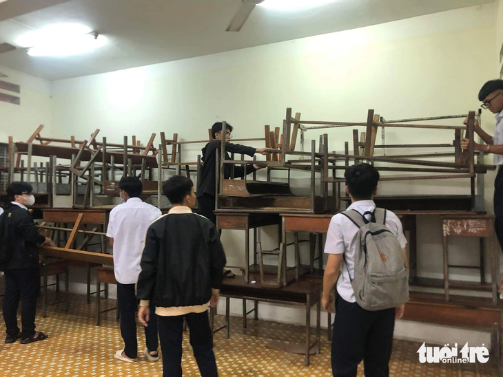 Các học sinh Trường THPT Hà Huy Tập (xã Vĩnh Thái, TP Nha Trang) kê bàn ghế lên cao - Ảnh: TRẦN HOÀI