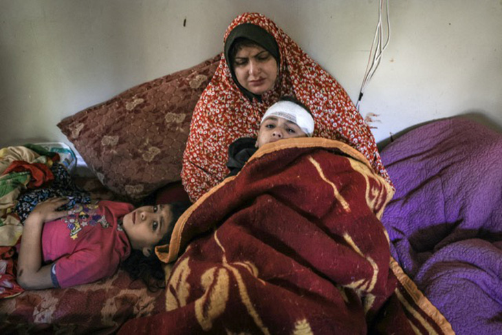 Một gia đình người Palestine may mắn sống sót từ vụ ném bom của Israel ở Dải Gaza - Ảnh: AFP