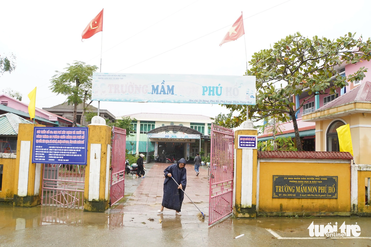 Các cô giáo Trường mầm non Phú Hồ (huyện Phú Vang, Thừa Thiên Huế) đội mưa đến trường dọn dẹp bùn đất sau ngập lụt - Ảnh: MINH ĐỨC