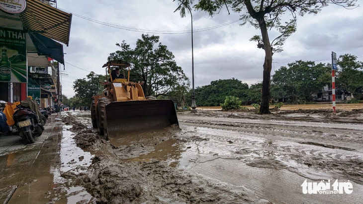 Nhiều tuyến đường ở TP Huế lầy lội bùn đất sau khi nước lụt rút dần. Lực lượng chức năng phải dùng máy xúc cỡ lớn để xúc bùn, trả lại đường sá cho người dân đi lại - Ảnh: NHẬT LINH
