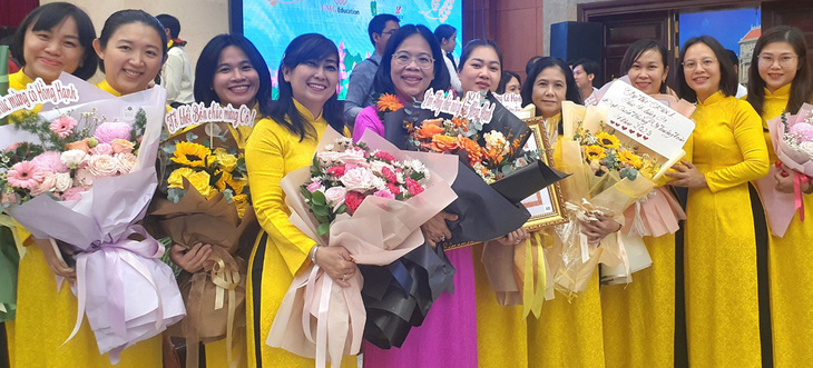 Đồng nghiệp chúc mừng cô Trần Bé Hồng Hạnh - hiệu trưởng Trường tiểu học Nguyễn Thái Học, quận 1 (áo tím) - tại buổi lễ vinh danh 50 nhà giáo tiêu biểu của TP.HCM