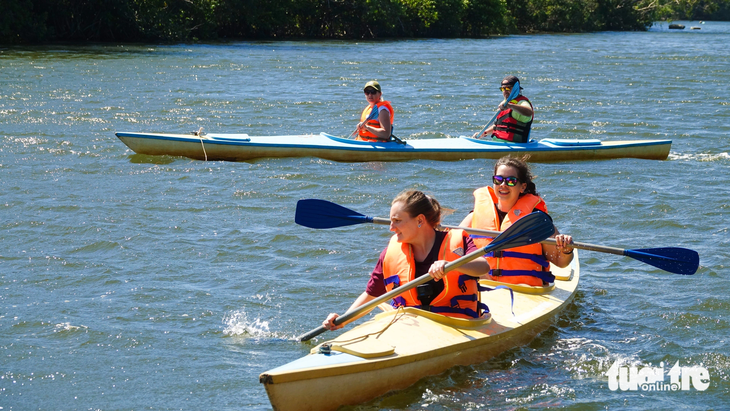 Khách quốc tế vui vẻ khi chèo thuyền kayak ngắm sông Cửa Cạn ở Phú Quốc - Ảnh: CHÍ CÔNG
