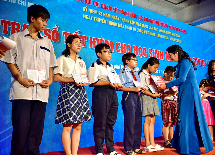 Chủ tịch Ủy ban Mặt trận Tổ quốc Việt Nam TP.HCM Trần Kim Yến trao sổ tiết kiệm cho học sinh mồ côi vì dịch COVID-19. Đợt này, có 200 em được nhận sổ tiết kiệm - Ảnh: T.T.D.