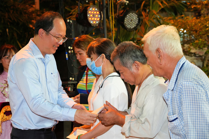 Phó bí thư Thành ủy TP.HCM Nguyễn Hồ Hải tặng quà cho các hộ nghèo, hộ cận nghèo trên địa bàn phường 6, quận 11, TP.HCM trong Ngày hội Đại đoàn kết  - Ảnh: HỮU HẠNH