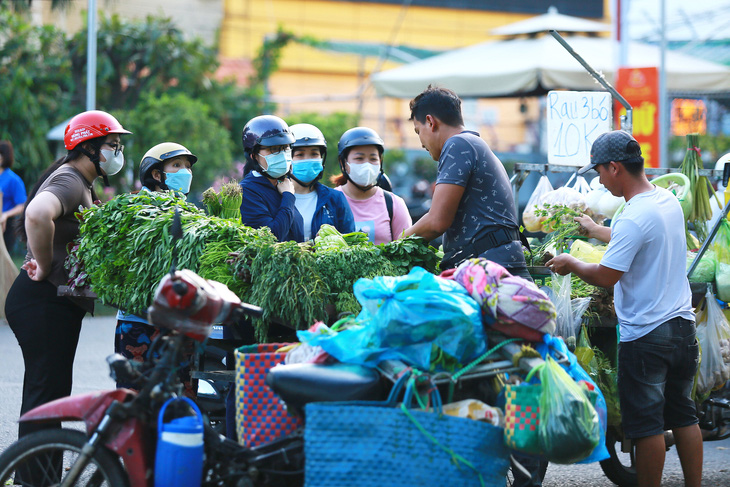 Kinh tế khó khăn, người lao động tiết kiệm để trang trải cuộc sống. Trong ảnh: công nhân Khu chế xuất Tân Thuận (quận 7, TP.HCM) đi chợ lề đường sau giờ tan ca - Ảnh: PH.QUYÊN