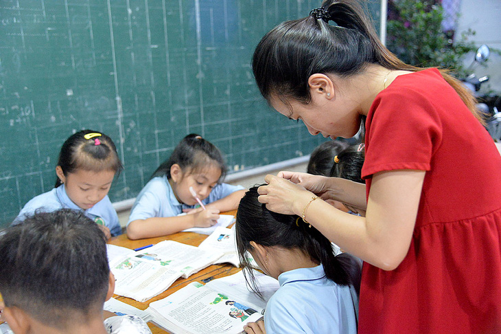 Tranh thủ lúc học trò làm bài tập, cô Hồng Nhung thay mẹ chăm sóc cho các cháu (ảnh chụp năm 2020)