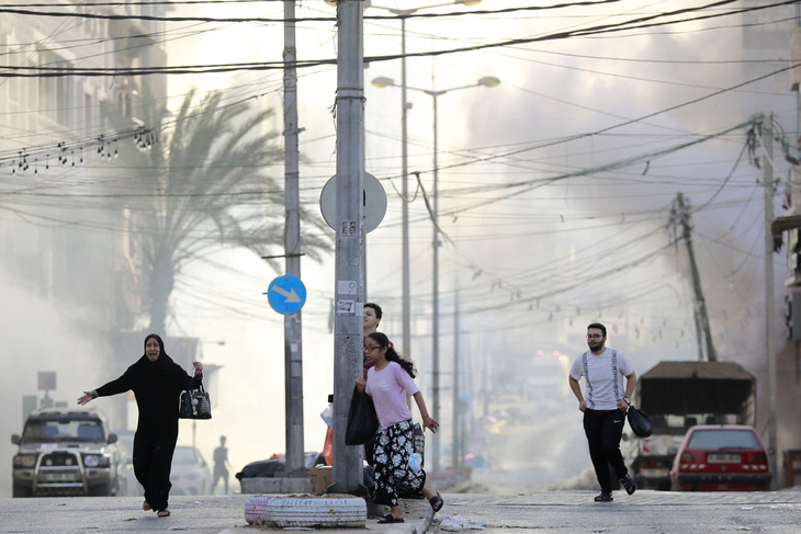 Người dân ở thành phố Gaza chạy trốn khỏi không kích và giao tranh giữa Israel và Hamas ngày 1-11 - Ảnh: AFP
