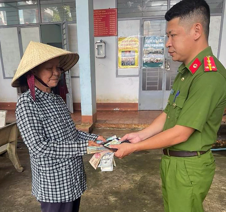 Bà Đinh Thị Hoa, người bán vé số nhặt được ví tiền chứa gần 20 triệu đồng, bàn giao cho lực lượng công an tìm kiếm người đánh rơi để trả lại - Ảnh: MINH ĐĂNG