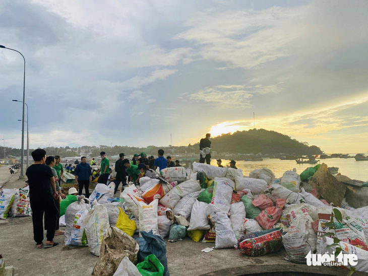 Lực lượng dân phòng, bộ đội biên phòng và các bạn tình nguyện trong nhóm Phú Quốc sạch và xanh thu gom rác thải sinh hoạt ở cảng Gành Dầu (TP Phú Quốc) - Ảnh: CHÍ CÔNG
