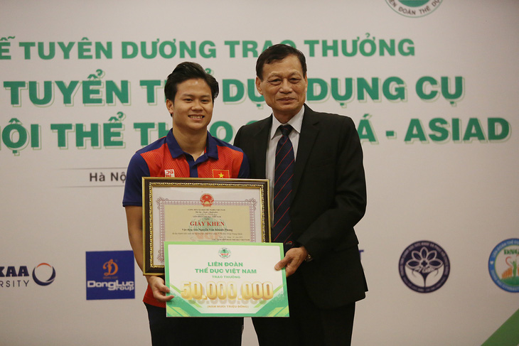 VĐV Nguyễn Văn Khánh Phong (bìa trái) nhận nhiều phần thưởng có giá trị sau khi giành huy chương bạc  Asiad - Ảnh: HOÀNG TÙNG