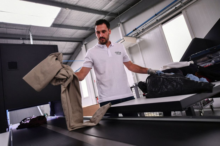 Một nhân viên đặt quần áo cũ lên máy phân loại hàng dệt may tại Cetia.Ảnh: afp.com