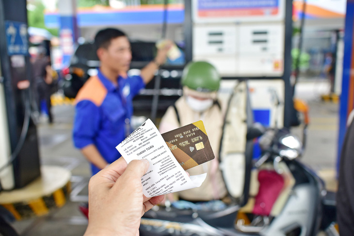 Khách trả tiền đổ xăng bằng thẻ tín dụng tại một cây xăng ở quận 1, TP.HCM vào chiều 1-11 - Ảnh: T.T.D.