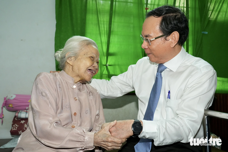 Bí thư Thành ủy Nguyễn Văn Nên thăm hỏi, trò chuyện cùng bà Phan Thị Nở - Ảnh: HỮU HẠNH