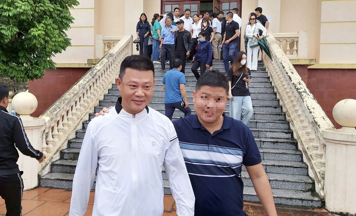 Ông Đinh Tiến Hùng (áo trắng) rời tòa - Ảnh: ANH HÒA
