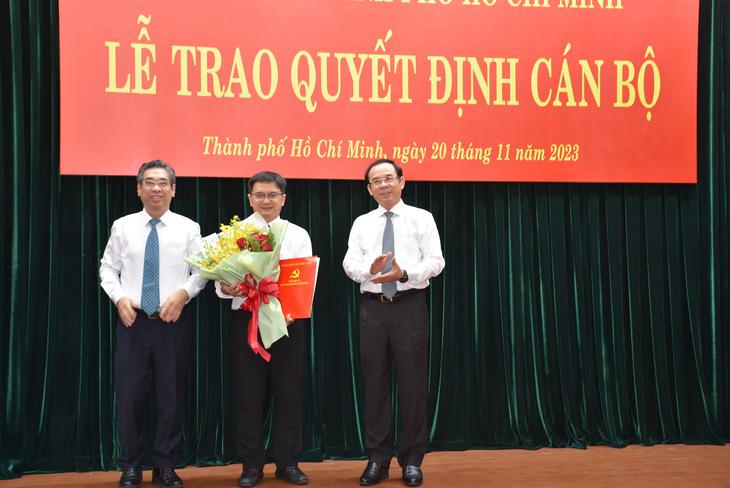 Bí thư Nguyễn Văn Nên (bìa phải) và Phó bí thư Nguyễn Phước Lộc trao quyết định và hoa chúc mừng cho trưởng Ban Dân vận Thành ủy Nguyễn Mạnh Cường - Ảnh: L.N