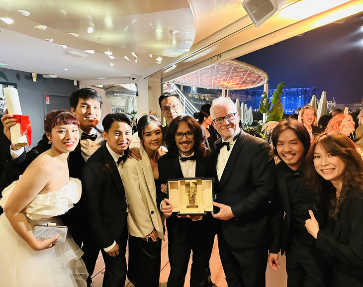 Đạo diễn Phạm Thiên Ân và đoàn làm phim Bên trong vỏ kén vàng chụp ảnh cùng giám đốc Liên hoan phim Cannes, sau khi bộ phim nhận giải Camera vàng vào tháng 5 vừa qua - Ảnh: NVCC