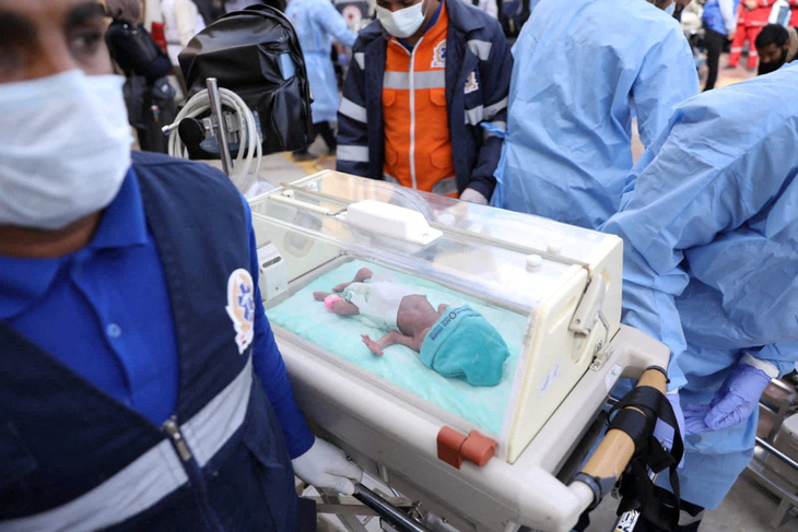 Các bác sĩ chuyển một em bé Palestine sinh non trong lồng ấp, sơ tán từ Dải Gaza sang xe cứu thương ở phía biên giới Rafah của Ai Cập, ngày 20-11. Xung đột đang leo thang giữa Israel và Hamas - Ảnh: REUTERS