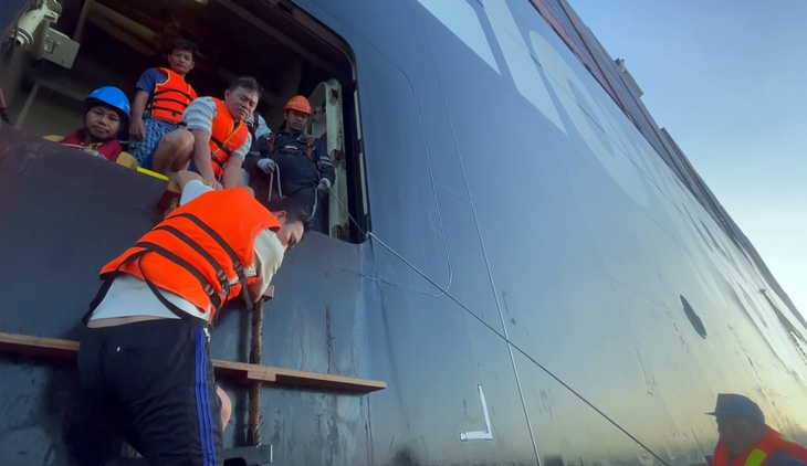 Ngư dân từ tàu Barzan xuống ca nô của tàu cảnh sát biển - Ảnh: ĐỨC ĐỊNH
