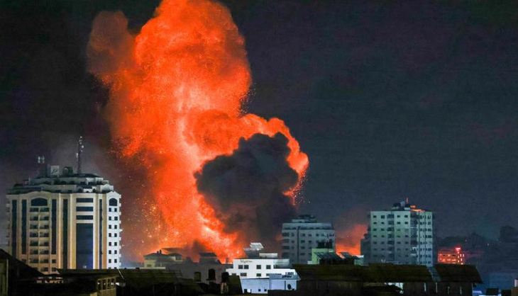 Một quả cầu lửa bùng lên phía trên thành phố Gaza sau cuộc không kích của Israel vào ngày 9-10 - Ảnh: AFP