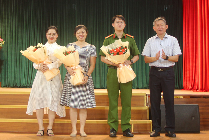 Ông Dương Trí Dũng, phó giám đốc Sở Giáo dục và Đào tạo TP.HCM (bìa phải) tặng hoa cảm ơn các báo cáo viên tại buổi tập huấn ngày 22-11 - Ảnh: H.HG